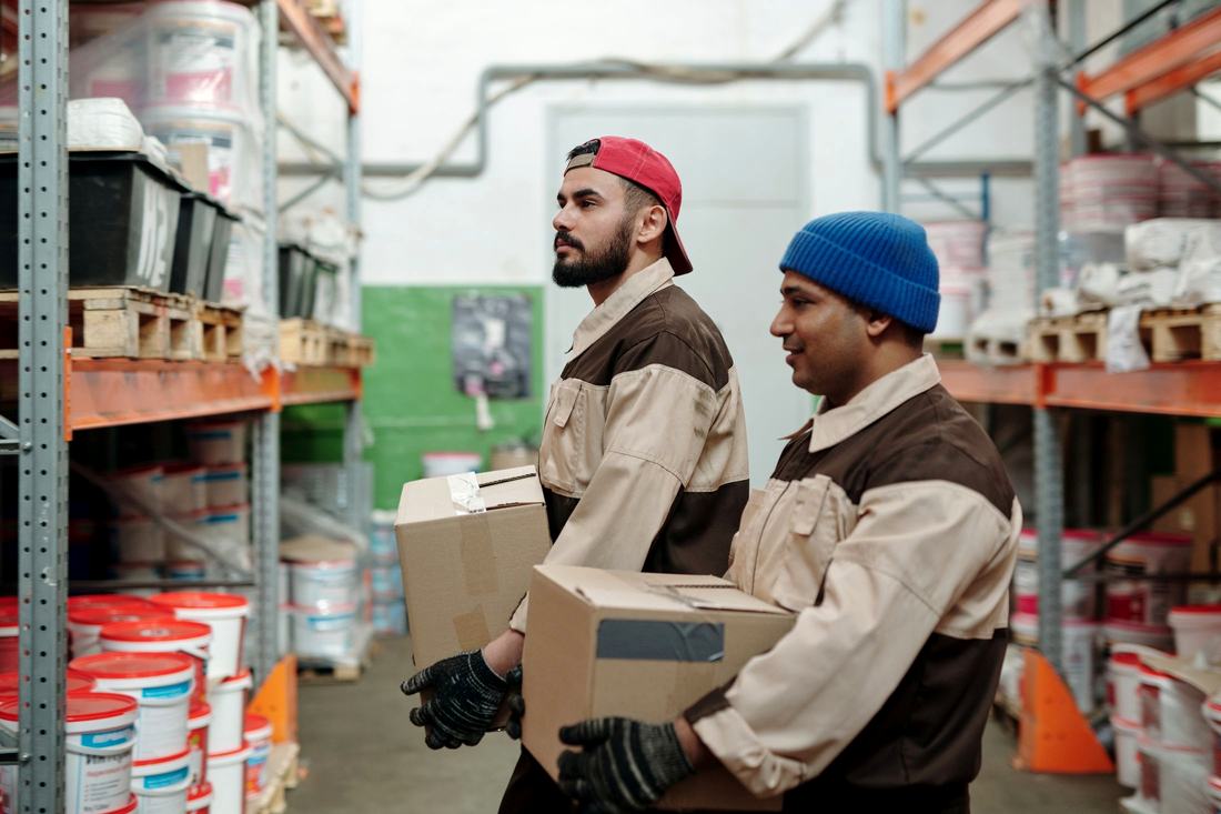 Warehouse staff carrying cartons to stage an order for dispatch
