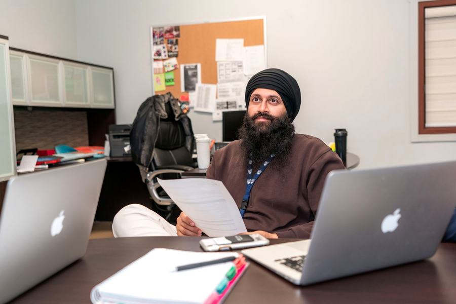 Professional working across two business laptops supplied through IT product procurement